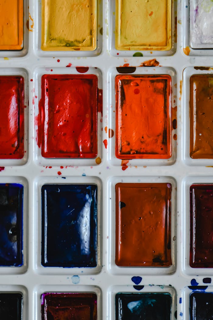 Close-up of a vibrant watercolor palette showcasing a variety of bright and warm colors.